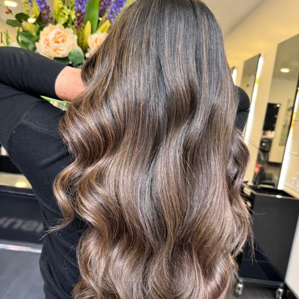 A back view of Lucy's wavy brown hair in our Salon